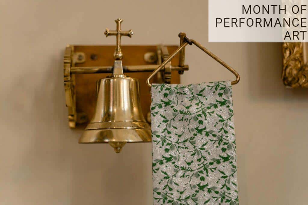 Brass bell with floral fabric decor, symbolizing faith and elegance inside a church.
