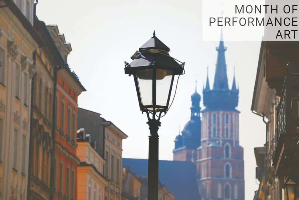 Street view featuring St. Mary's Basilica and a historic lamp post in Kraków, Poland.